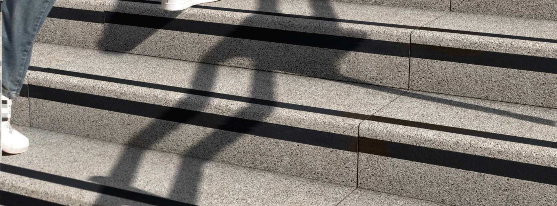A member of the public walking up Marshalls Conservation X silver grey steps 