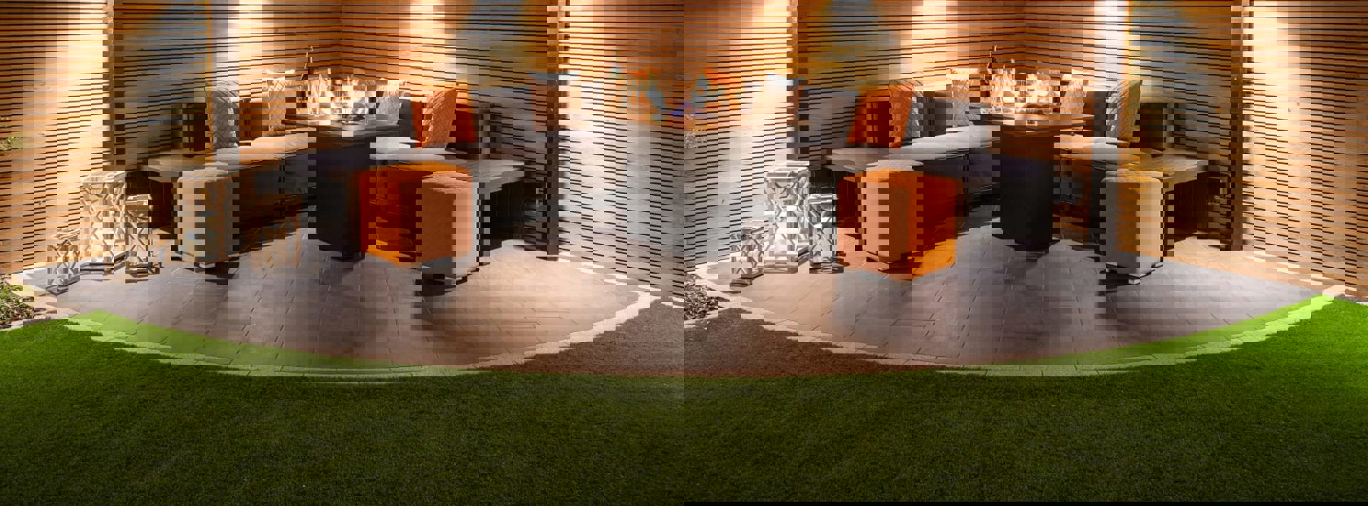 Marshalls Arrento paving laid in a garden with modern grey garden seating at night