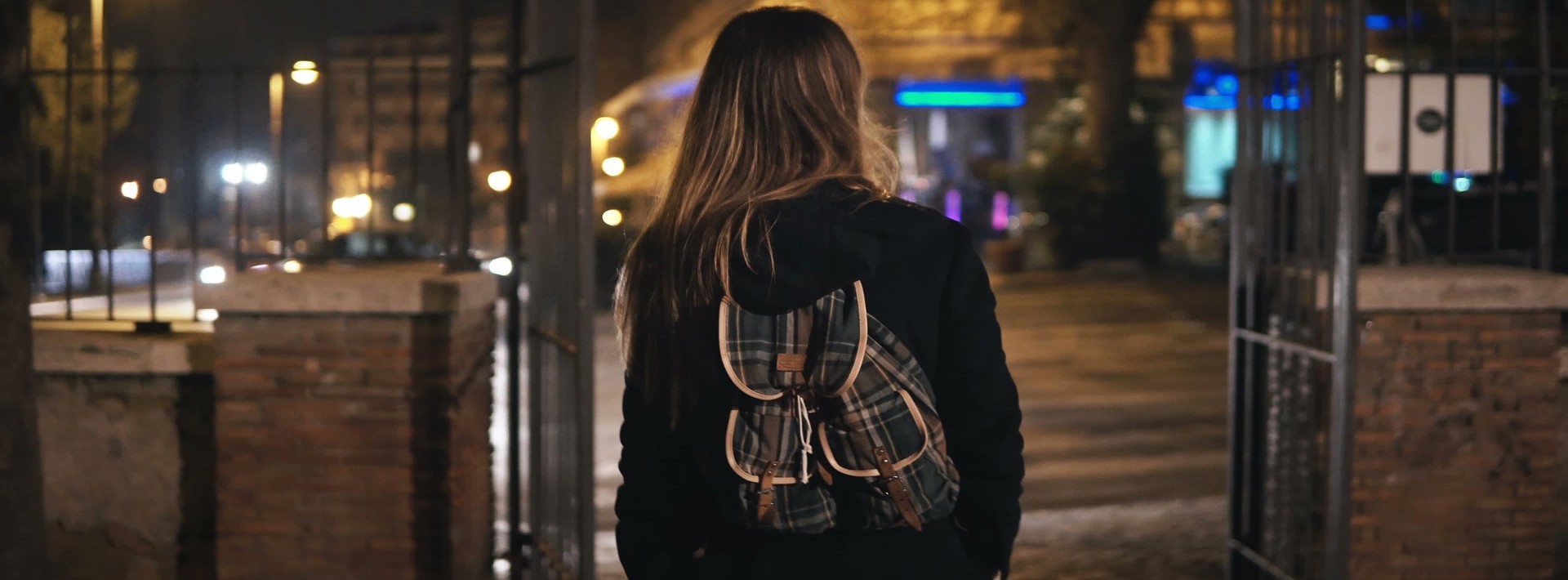 A female walking with a rucksack on in the dark