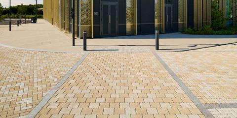 Modal X textured paving laid outside a yellow building
