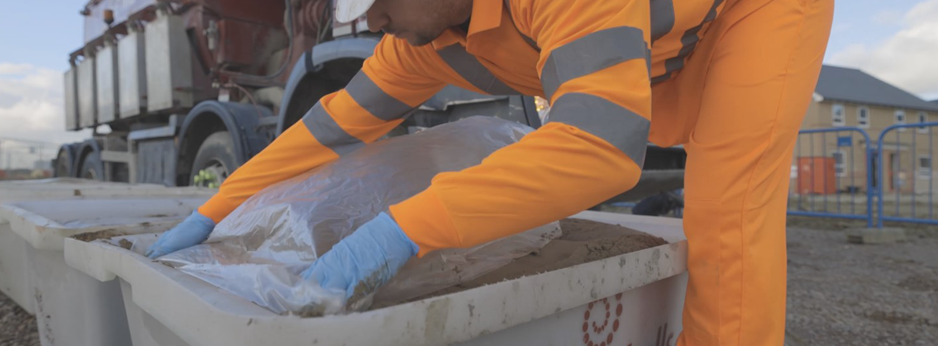 A Marshalls site member in orange high vis workwear wrapping a mortar tub