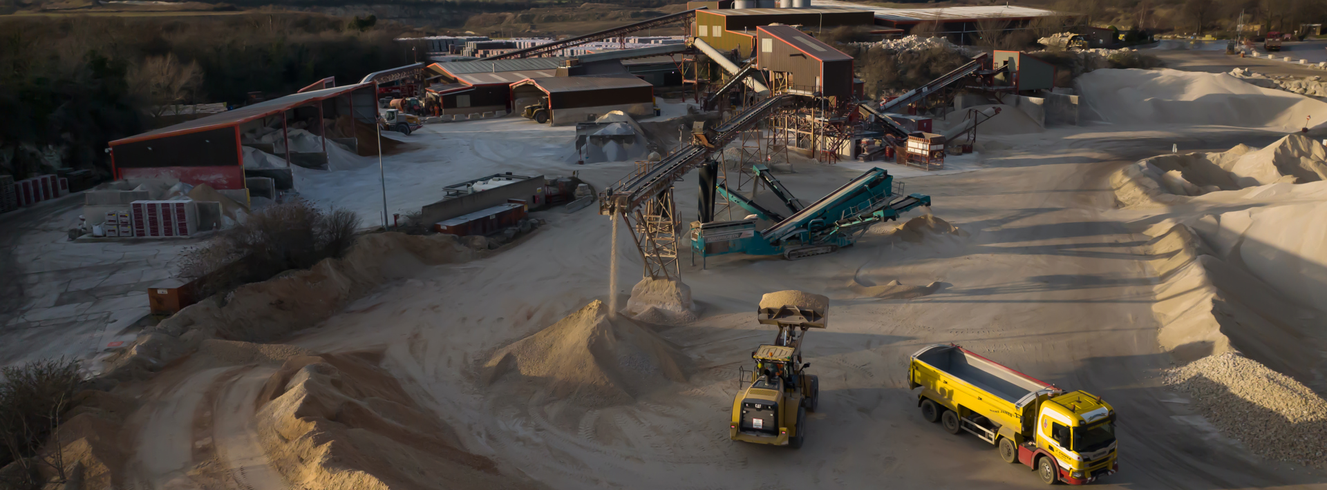 A site in action with lorries and diggers moving aggregates around