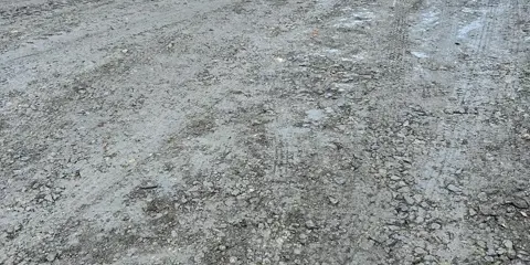 An uneven road made up of stones and mud