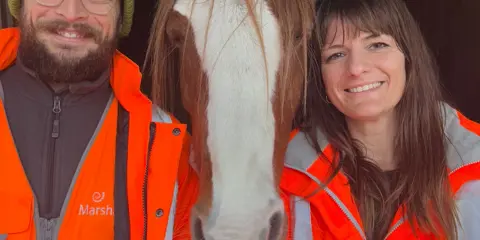 Marshalls aggregates staff stood in high vis workwear next to a horse