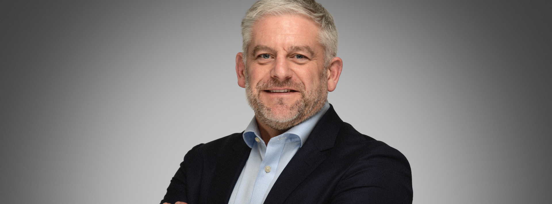 Simon Bourne in a blue shirt and a black suit jacket