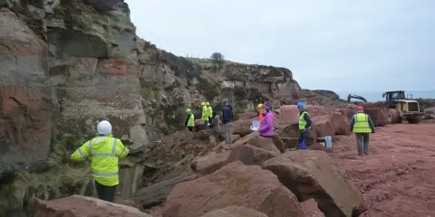 Staff on-site in high vis wear reviewing the stone