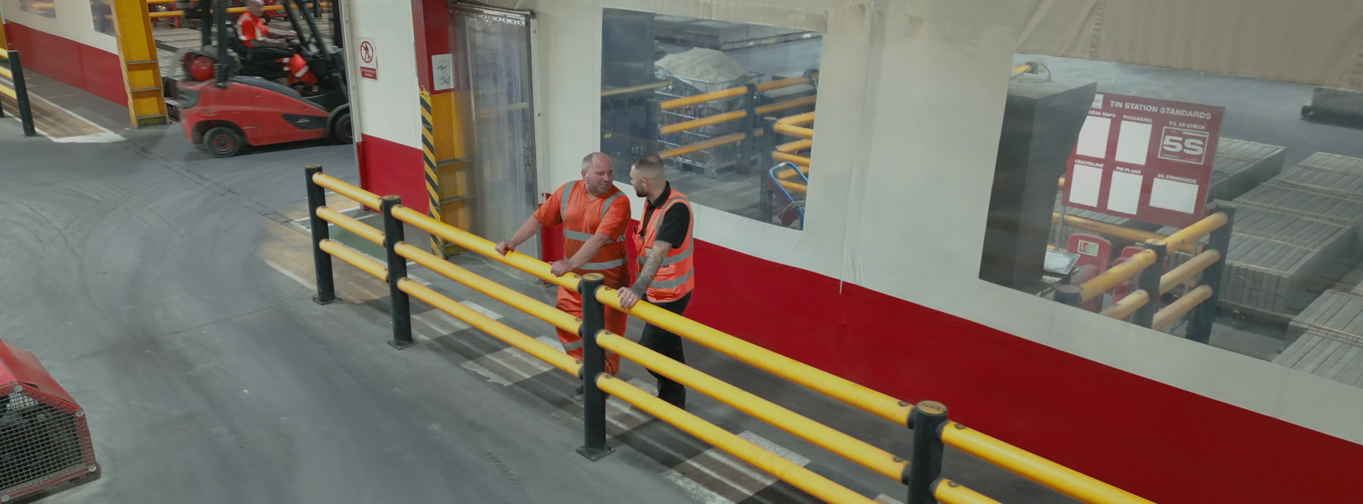 Marshalls staff talking to each other behind a yellow safety bar