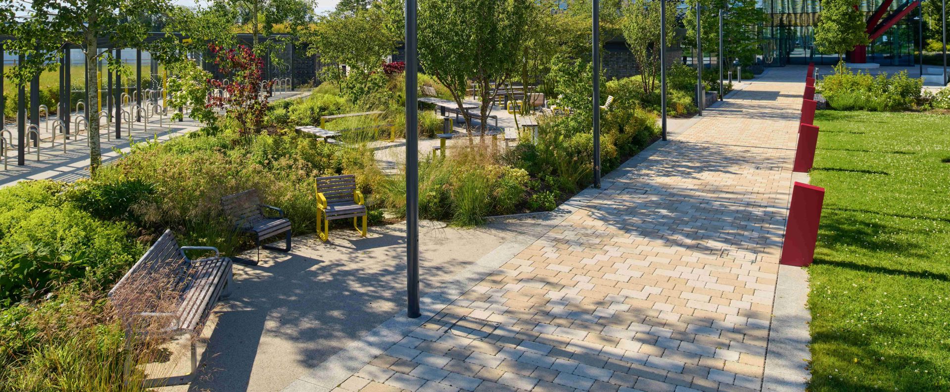 Modal X paving laid on a pathway next to wooden furniture and lots of greenery