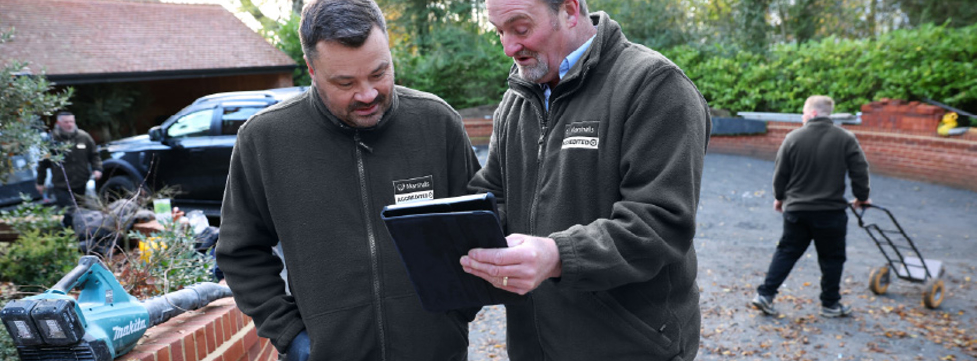 A Marshalls assessor talking to a Marshalls Accredited member with a tablet