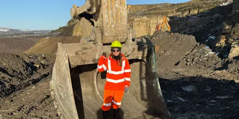 Marshalls members of staff stood on-site in front of a digger