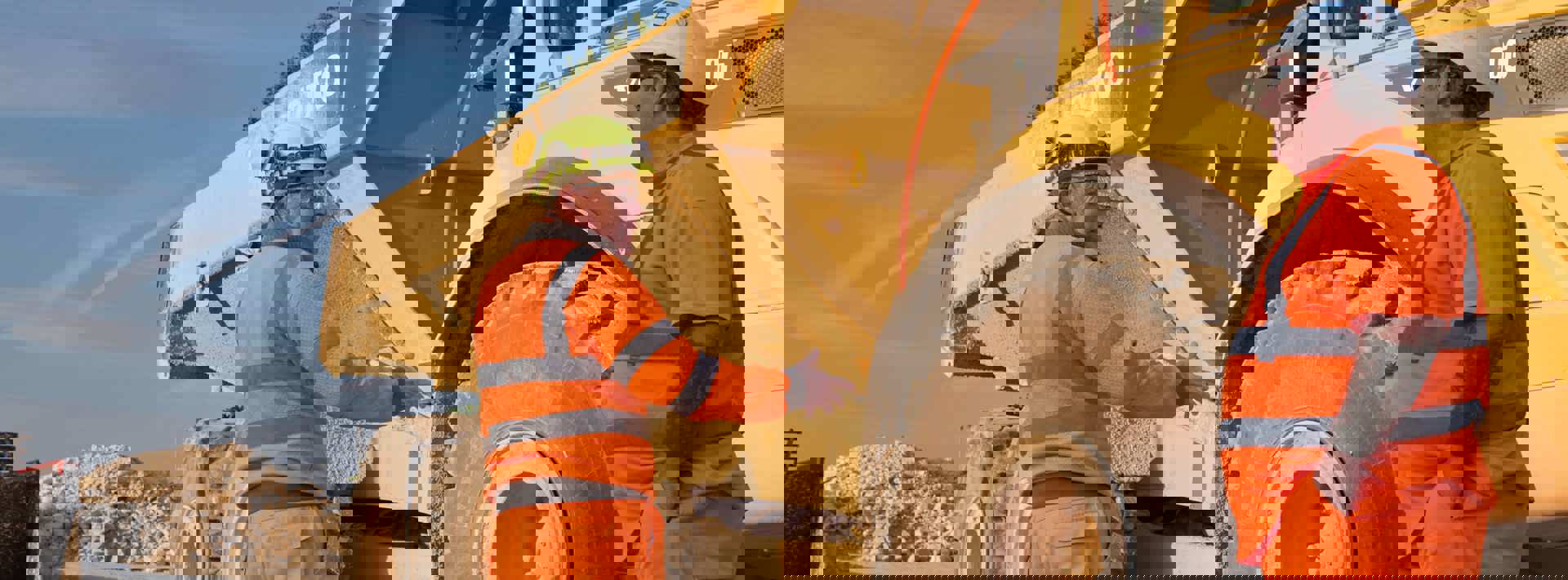 Aggregates team in high vis workwear talking next to machinery