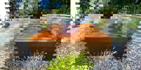 A modern garden with Marshalls Casarta slate paving and a brown square water feature