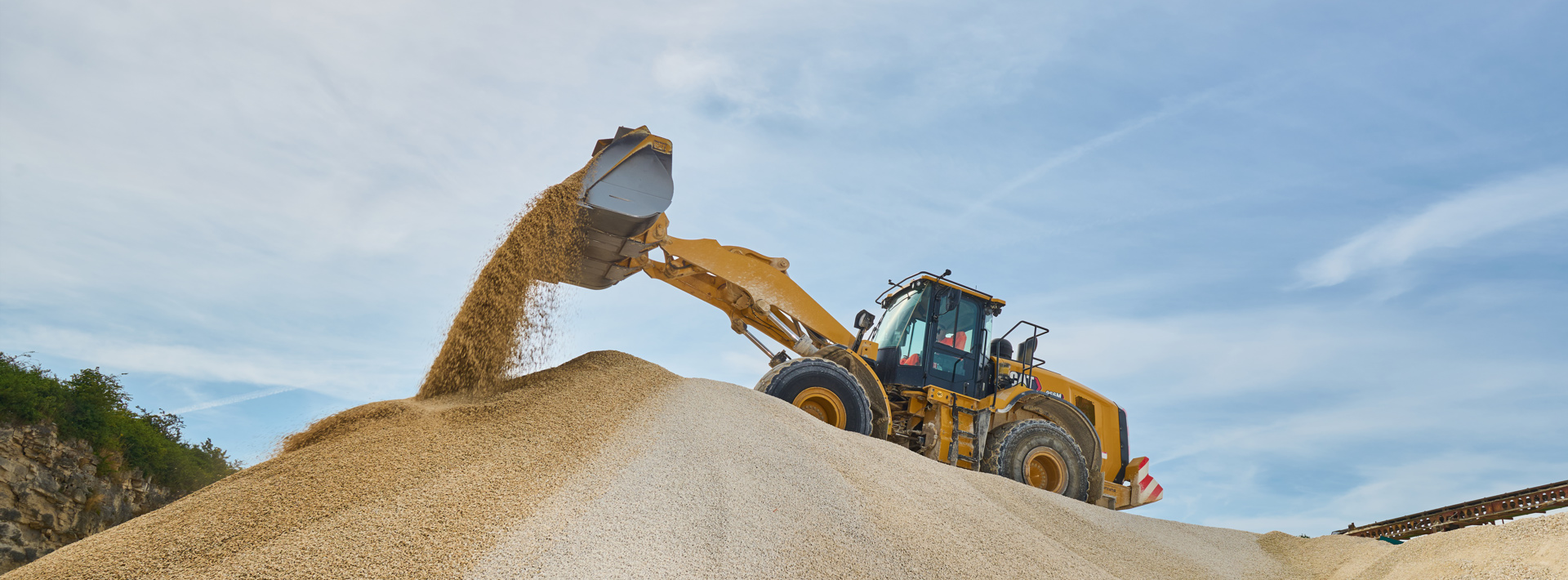 A digger on top of a pile of aggregates 