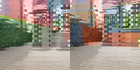 Marshalls Lunar paving in rosa laid on a driveway in front of a red brick house